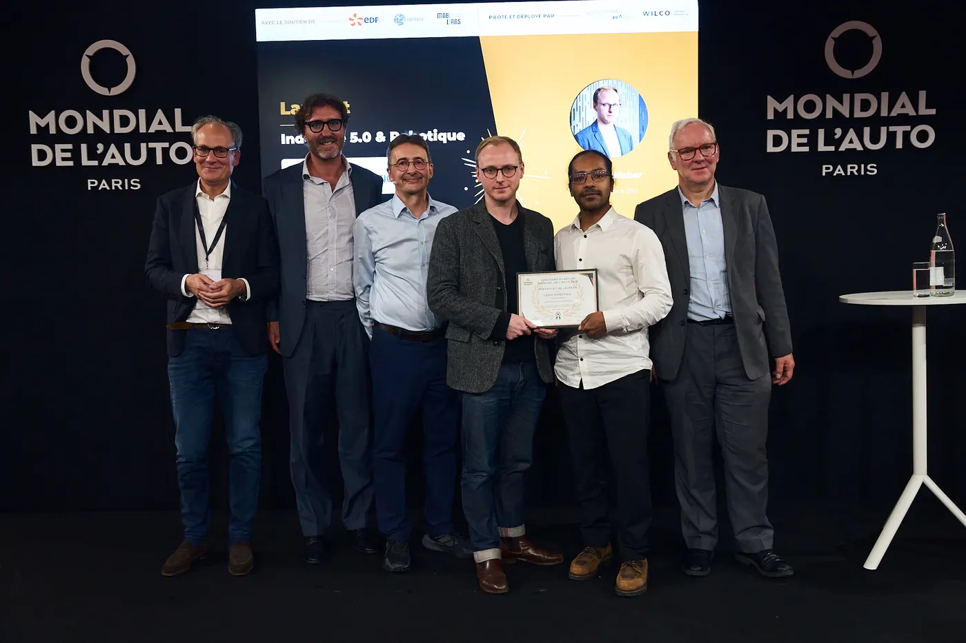 The Lexio Robotics founders receiving the startup prize on stage at the Mondial de l’Auto 2026 in Paris